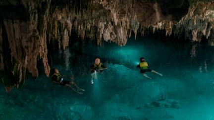 Tour group exploring a cave cenote